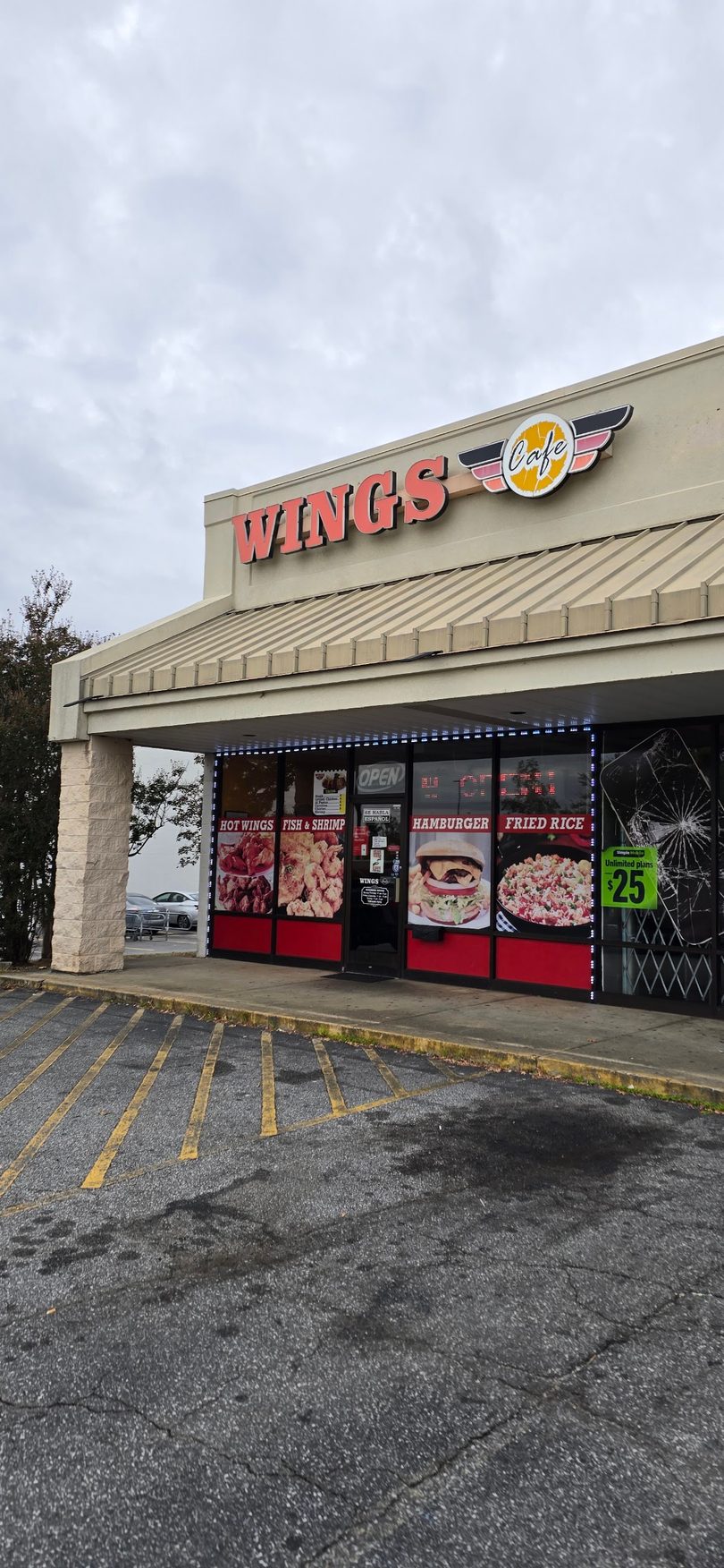 Exterior of Wings Cafe restaurant with menu images of hot wings, fish, shrimp, hamburger, and fried rice.